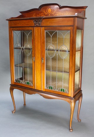 An Edwardian inlaid mahogany display cabinet fitted shelves enclosed by lead glazed panelled doors raised on cabriole supports 66" x 42" x 14" 