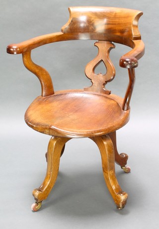 A Victorian mahogany tub back revolving office chair raised on shaped supports 