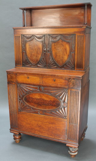 A 19th Century Anglo Indian mahogany cabinet the upper section enclosed by a panelled door, the base fitted 2 short drawers above a double cupboard flanked by fluted columns and raised on bun feet 65"h x 34"w x 19"d (made up) 