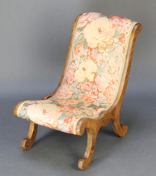 A Victorian mahogany show frame nursing chair upholstered in floral material (stretcher missing to front and rear) 