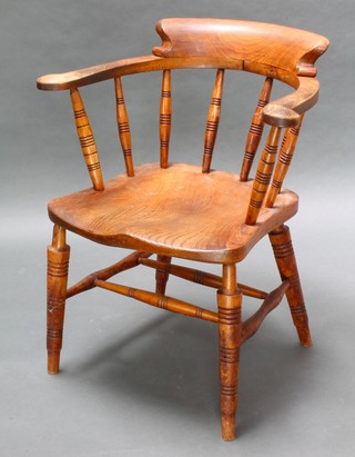 Glenister of Wycombe, a Victorian elm smokers bow chair with spindle turning, the reverse marked VR Glenisters Wycombe 