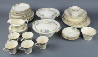 An Art Deco tea and dinner service comprising 5 tea cups, 6 saucers, milk jug, sugar bowl, 6 small plates, 6 medium plates, 6 dinner plates, 6 large plates, 2 tureens and covers, a sauce boat, 6 dessert bowls, a fruit bowl, 4 serving plates 