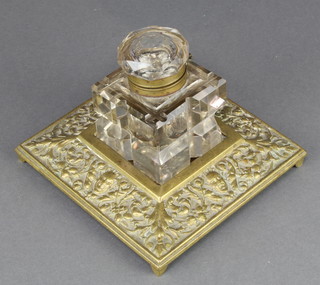 A Victorian square cut glass inkwell raised on a cast brass base with mask decoration 4" x 6" x 6" 