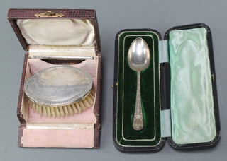 A cased silver spoon Sheffield 1906 together with a silver backed hairbrush
