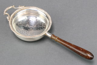 A silver tea strainer with turned wood handle Birmingham 1961 