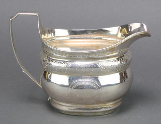 A George III silver milk jug with chased decoration and monogram 150 grams 