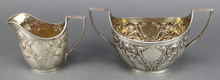 An Art Nouveau silver repousse milk jug and 2 handled sugar bowl Sheffield 1902, 415 grams