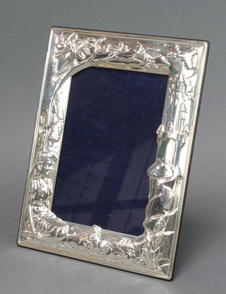 A sterling silver repousse photograph frame with Alice in Wonderland decoration 7" x 5 1/2" 