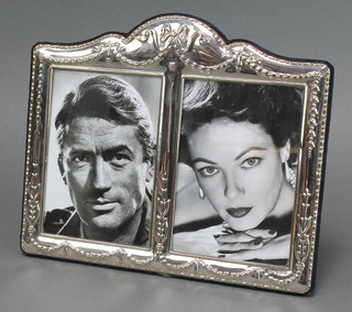 A sterling silver repousse double photograph frame with swags and ribbon decoration 8 1/2" x 7" 
