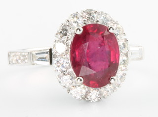An 18ct  white gold oval ruby and diamond cluster ring, the centre stone approx. 3.11ct surrounded by diamonds approx 0.84ct, size M