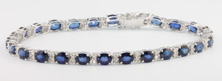 An 18ct white gold sapphire and diamond line bracelet, sapphires 11.5ct, diamonds 0.67ct, 80mm long