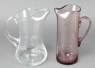 A Whitefriars clear glass jug 10 1/2" and a purple jug 10" 