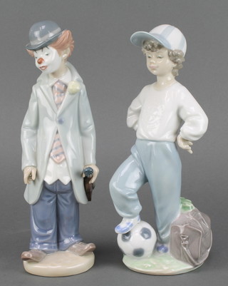 A Lladro figure of a boy with his foot on a football 8", a do. of a clown holding a violin 8 1/2" 
