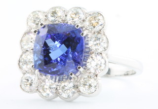 An 18ct white gold cushion cut tanzanite and diamond ring, the centre stone approx. 4ct surrounded by 12 brilliant cut diamonds  approx. 1.60ct size O 1/2