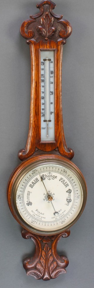 An aneroid barometer and thermometer contained in a carved oak wheel case 