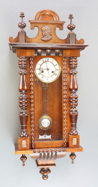 A Vienna style wall clock with 5" enamelled dial, grid iron pendulum contained in a walnut case 