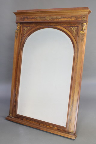 A French Empire style arched bevelled plate mirror contained in a walnut and gilt mounted frame with Egyptian masks 60" x 41"