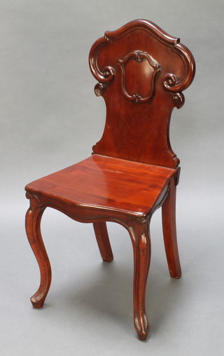 A Victorian carved mahogany hall chair with shaped solid seat and back, raised on cabriole supports