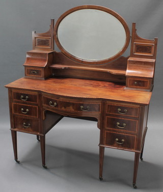 An Edwardian inlaid mahogany Sheraton style bow front dressing table with arched bevelled plate mirror to the back above recesses enclosed by panelled doors and glove drawers, the base fitted 1 long drawer flanked by 6 short drawers, raised on square tapered supports 63"h x 53"w x 23"d 