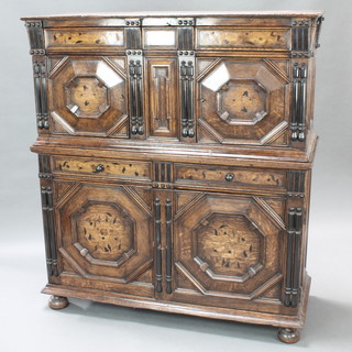 An 18th style Century Dutch inlaid oak court cupboard, the upper section fitted a secret drawer above double cupboards enclosed by panelled doors, the base fitted a double cupboard enclosed by panelled doors, raised on bun feet 65 1/2" x 49 1/2" x 20"
