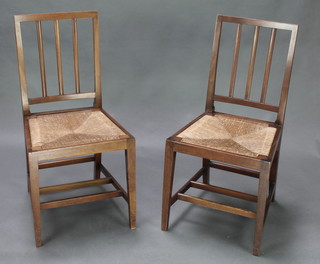 A pair of Edward VII walnut stick and rail back chairs with woven rush seats, raised on square tapered supports, the back bar marked ER VII with a crown Coronation 