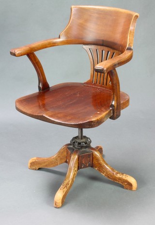 An Edwardian mahogany tub back revolving office chair with solid seat