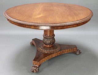 A William IV circular mahogany snap top breakfast table raised on a turned column and chamfered base with paw feet 29"h x 49" diam. 