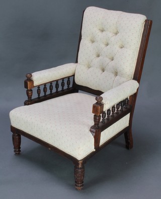 An Edwardian carved mahogany show frame armchair upholstered with bobbin turned decoration, upholstered in cream coloured material, raised on turned supports 