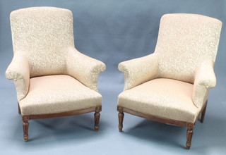 A pair of French style walnut armchairs upholstered in gold material  