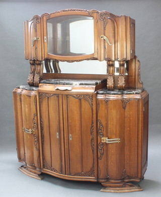 An Art Deco German carved oak chiffonier sideboard, the raised back fitted a cupboard with mirrored panelled back enclosed by a glazed panelled door,  flanked by pair of cupboards, the base fitted a drawer above triple cupboards with black veined marble panels to the top 75"h x 61"w x 21"d