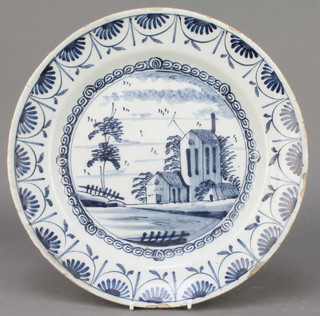 An 18th Century English blue and white Delft ware plate decorated with a building enclosed in a leaf border 12" 
