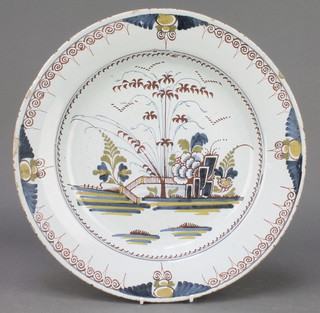 An 18th Century English polychrome Delft ware shallow bowl decorated with a garden view having a geometric border 13 1/2" 