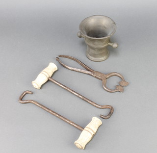 An 18th Century brass twin handled mortar 4", a pair of 19th Century polished steel and bone handled boat hooks 10" and a 19th Century sugar cutter 9" (missing clip from end)
