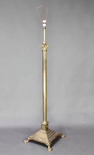 A Victorian brass adjustable standard oil lamp with Corinthian capital and reeded column raised on a square stepped foot with paw brass feet, converted to use with electricity 48"h x 12" x 12" 