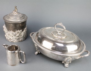 An Edwardian silver plated biscuit barrel decorated with cavorting cherubs, an entree and jug 