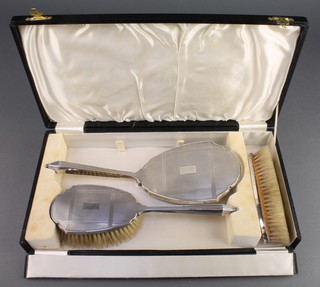 A silver backed 3 piece brush set Birmingham 1932, cased