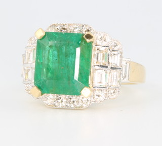 An 18ct yellow gold Art Deco style emerald and diamond ring, the centre stone approx. 3.48ct surrounded by brilliant and baguette cut diamonds approx. 1.23ct, size M 