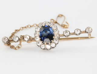 A yellow gold sapphire and diamond bar brooch, the oval centre sapphire surrounded by brilliant cut diamonds and flanked by 3 diamonds 