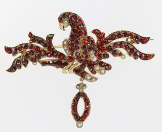 An unusual Victorian gold plated garnet and seed pearl articulated brooch in the form of a bird sitting among leaves 