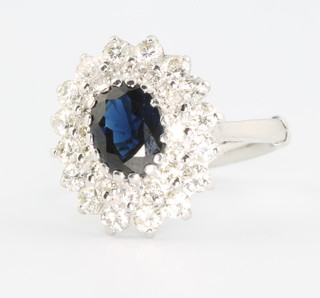 An 18ct white gold oval sapphire and diamond cluster ring the centre oval stone surrounded by 2 tiers of brilliant cut diamonds size K 