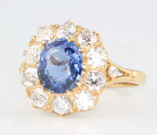 An 18ct yellow gold sapphire and diamond cluster ring, the centre oval stone approx. 2.5cts surrounded by 10 brilliant cut diamonds approx. 1.25ct size N 1/2