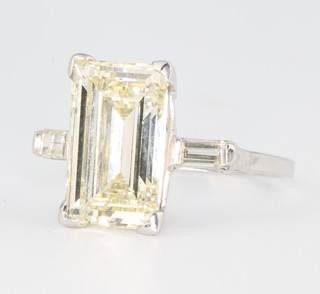 An 18ct white gold emerald cut single stone diamond ring 5ct, colour L, clarity VS, flanked by 2 baguette cut diamonds approx 0.2ct, colour G-H with a clarity of VS, size N together with an EDR diamond report