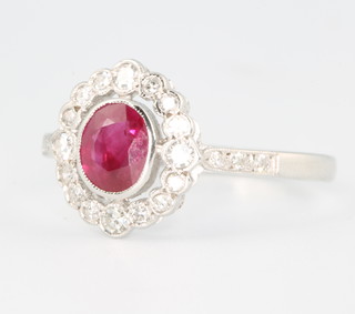 An 18ct white gold oval ruby and diamond cluster ring, the centre stone approx 0.85ct surrounded by 16 brilliant cut diamonds approx. 0.35ct size P 