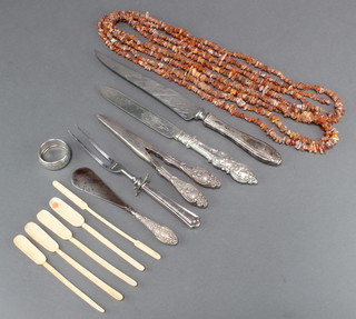 A string of natural amber beads, minor bone items and plated cutlery including silver handled implements