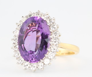 An 18ct yellow gold amethyst and diamond oval dress ring size N 1/2