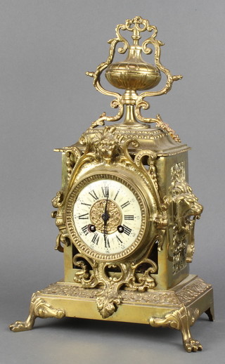 A 19th Century French 8 day striking mantel clock with enamelled dial and Roman numerals contained in a pierced and gilt metal Rococo style case surmounted by a lidded urn with lion mask handles  