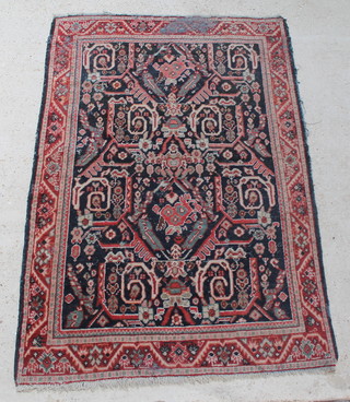 A blue and red Persian rug with geometric design within multi-row border 77" x 53" 