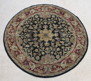 A black ground and floral patterned circular Indian wool rug 68" diam. 