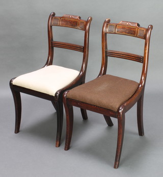 A pair of Regency inlaid mahogany bar back dining chairs with plain mid rails and upholstered drop in seats, raised on sabre supports