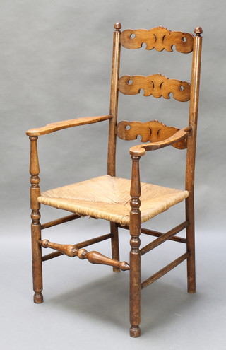 A pierced elm ladderback carver chair with woven rush seat
